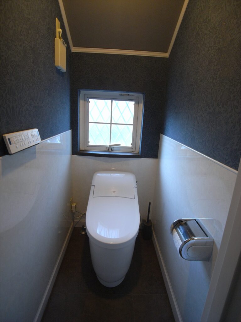 トイレの腰壁にお掃除のしやすいパネルを貼りその上をブルー系のクロスを貼りました。