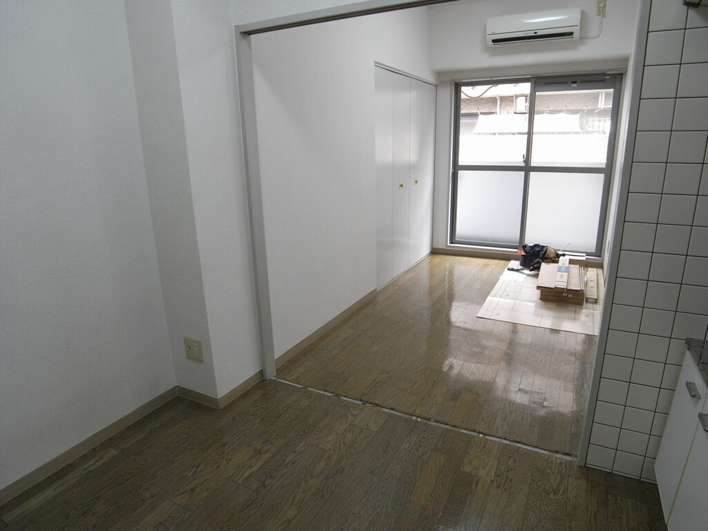 横浜市西区でフローリングの上にはめ込み式のフロアタイルを設置する前の写真。引き違い戸の敷居を外しています。