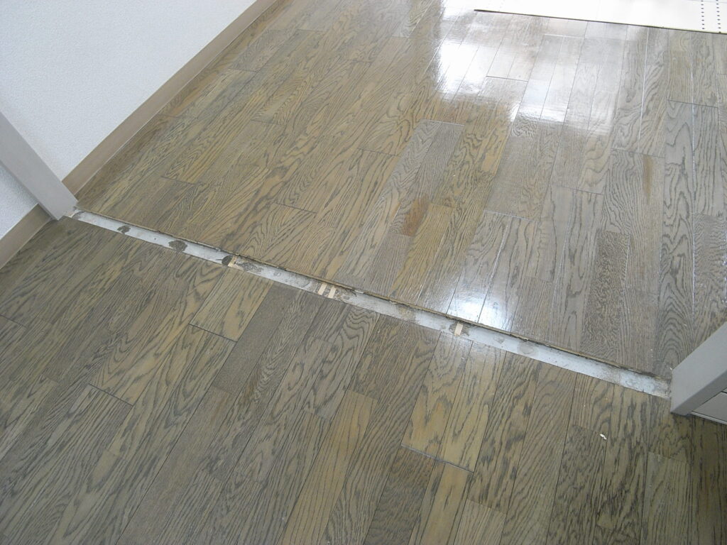 横浜市西区でフローリングの上にはめ込み式のフロアタイルを設置する前で、引き違い戸の敷居を外しています。