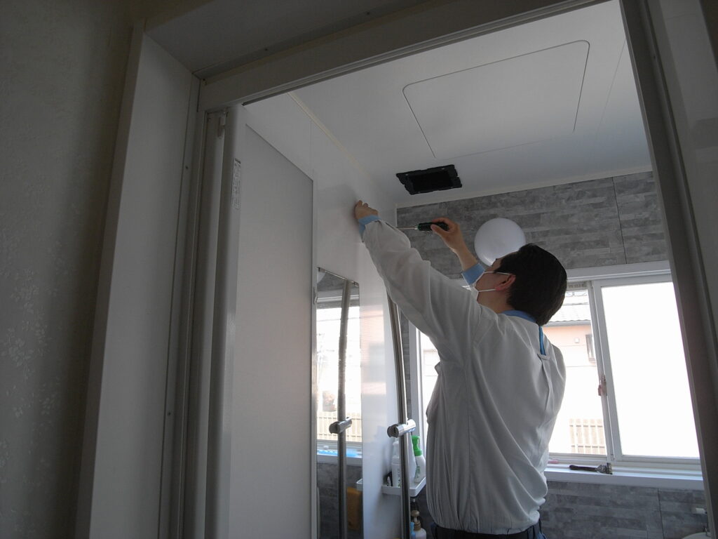 スライドハンガーの上のほうを外そうとしています。