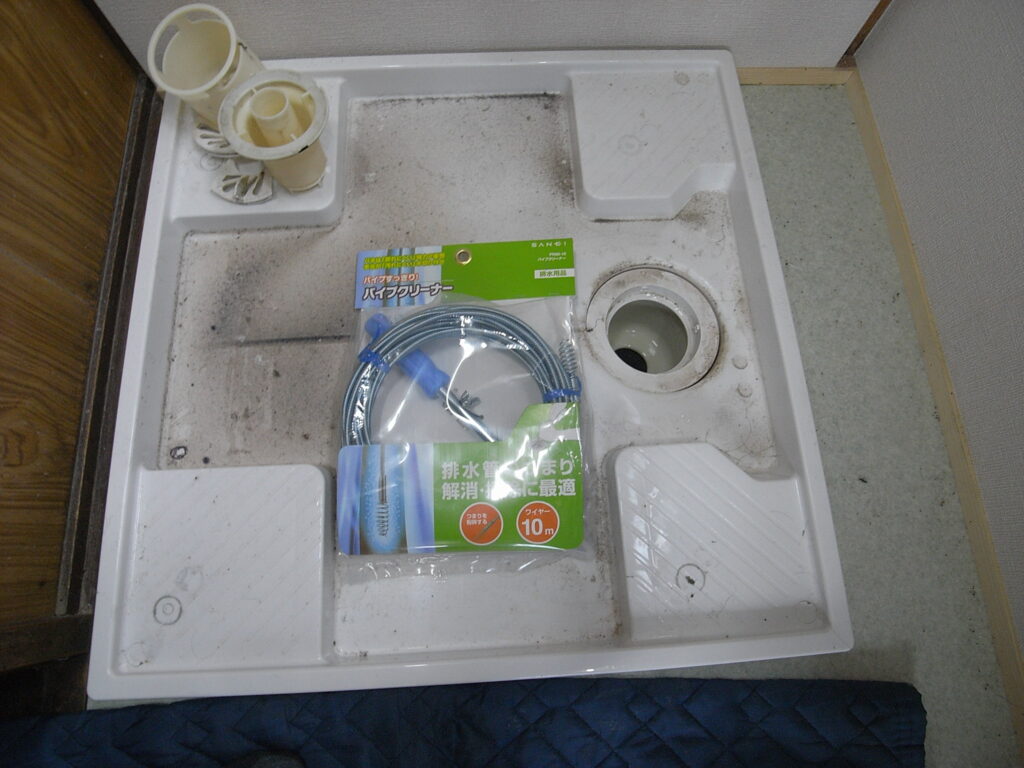 洗濯機用の防水パンの排水がつまったので、パイプクリーナーを使って排水管のつまりを解消する作業を行う前です。